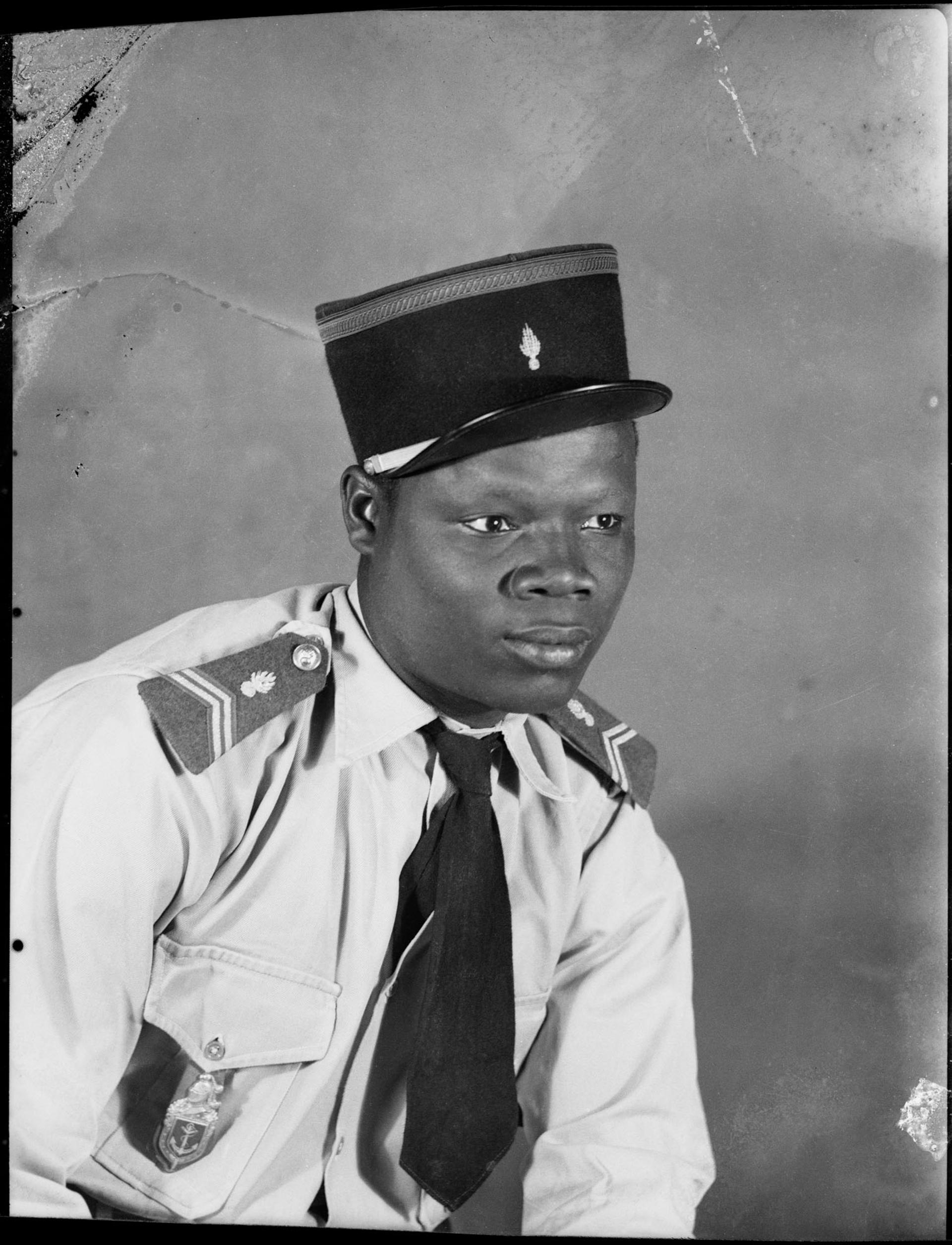 Black-and-white photograph showing a person in a military-style uniform and cap