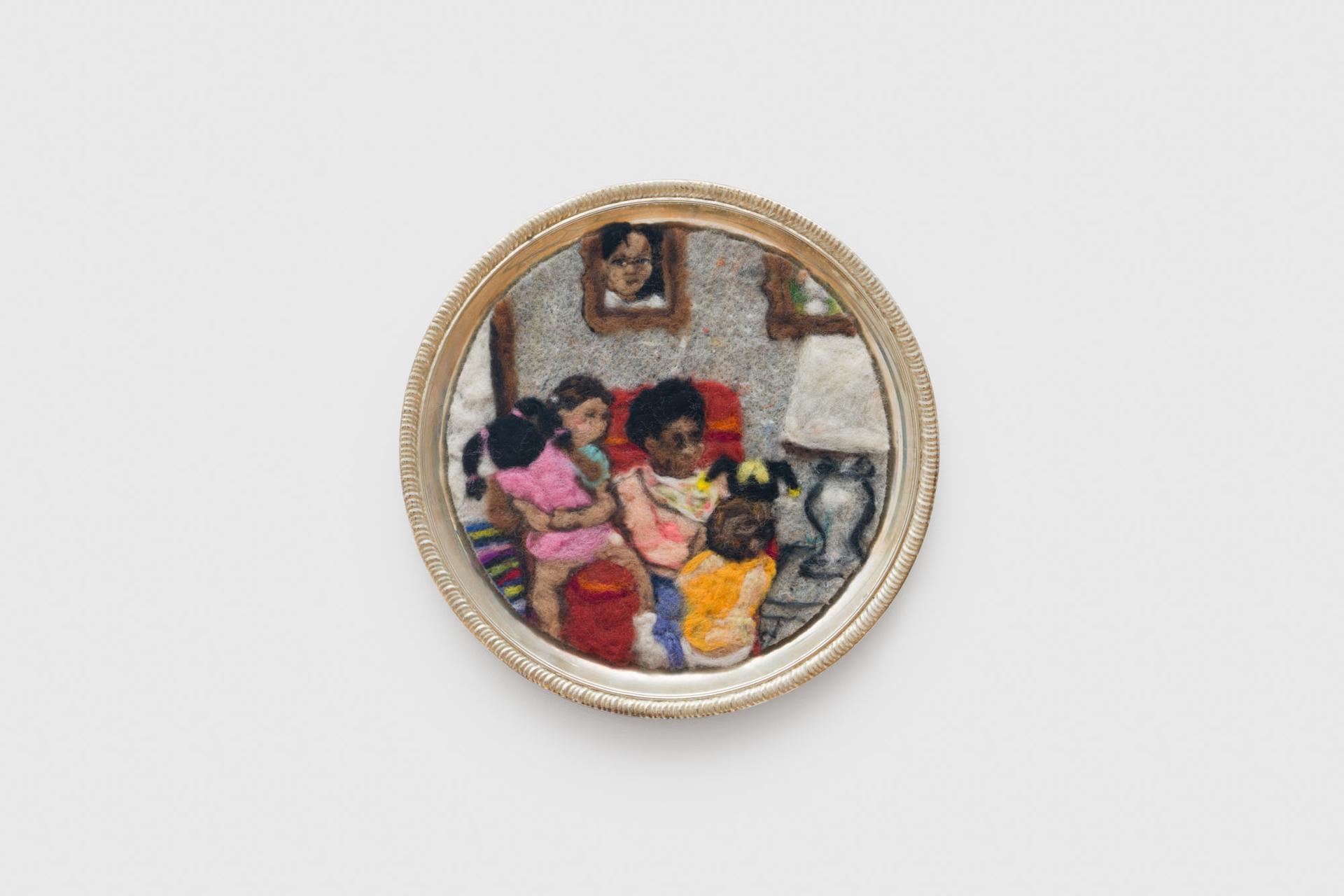 Felted artwork of a family in a silver circular frame