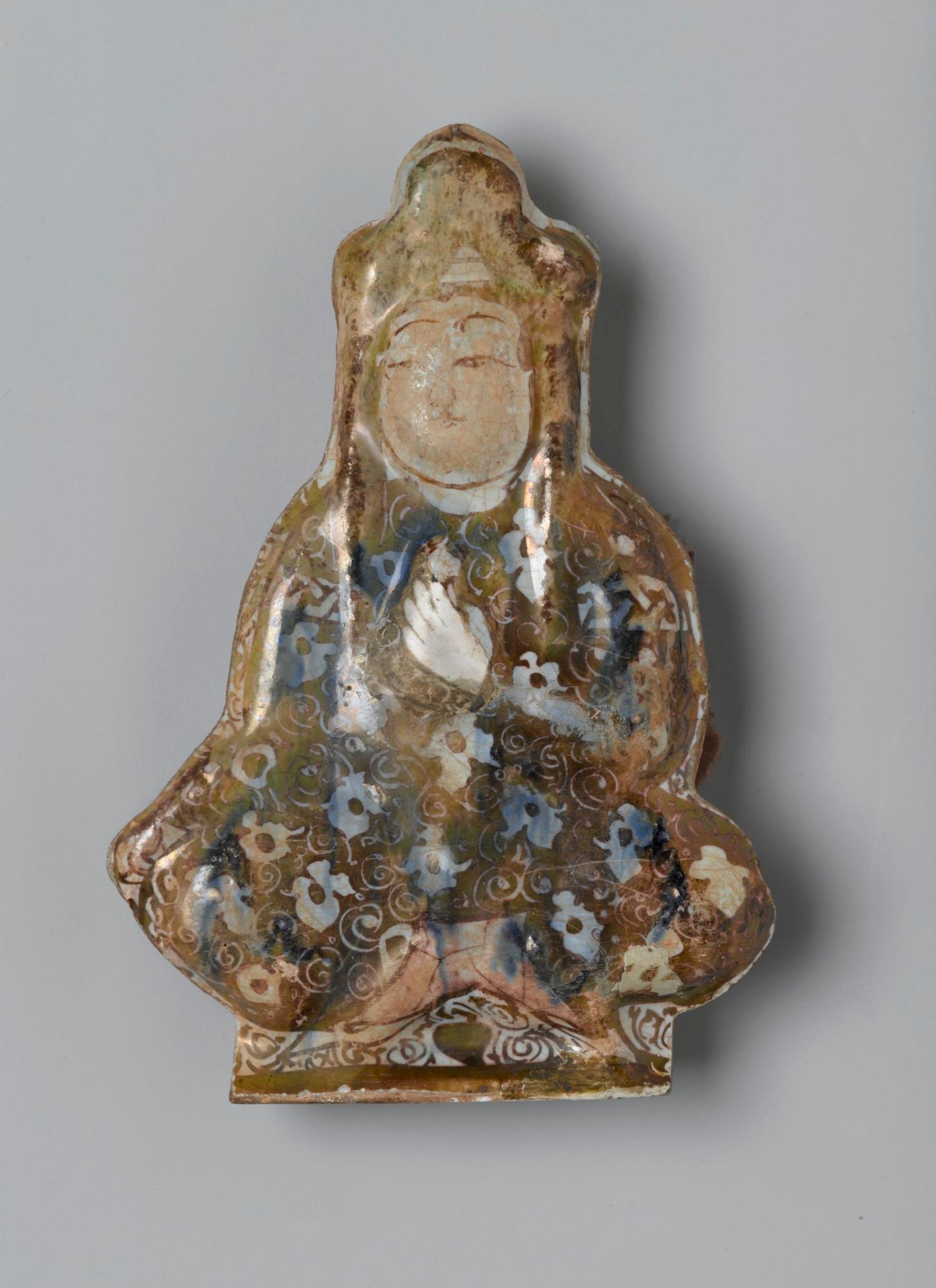 Tile in the Shape of a Seated Figure, Iran (probably Kashan), early 13th century. Ceramic; fritware, molded, underglaze painted, overglaze lustered, 5 1/2 × 4 in. (14 × 10.2 cm). Brooklyn Museum, Gift of the Ernest Erickson Foundation, Inc., 86.227.69. (Photo: Brooklyn Museum)