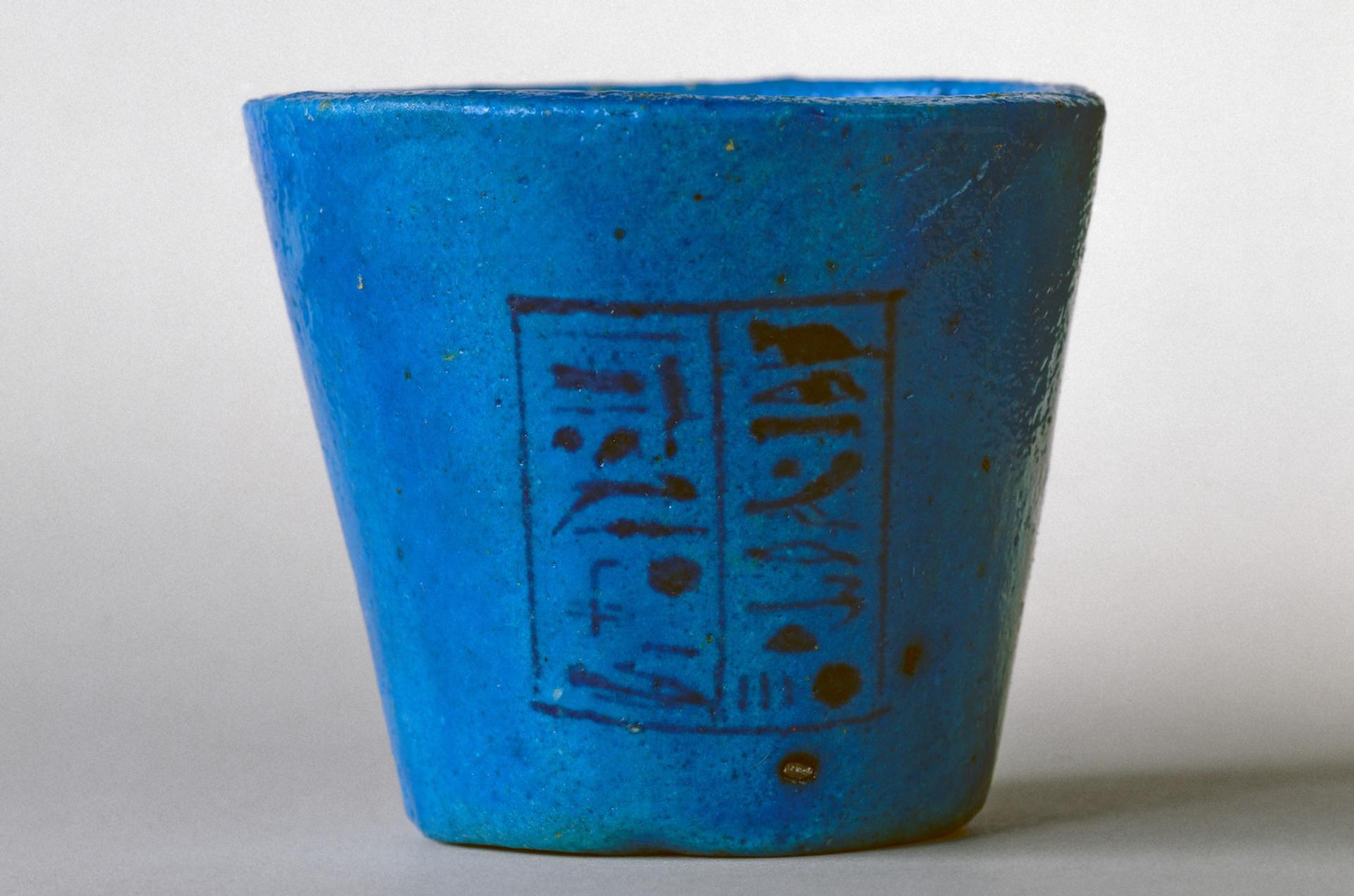 Bright blue cup with two columns of black hieroglyphic writing on the front