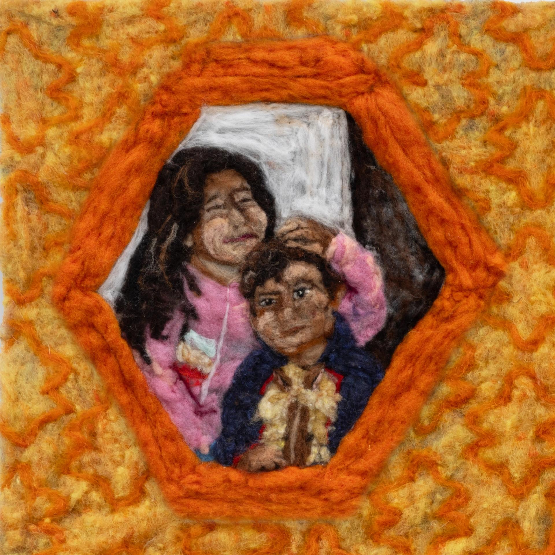 Detail of felted artwork showing two children framed in an orange hexagon