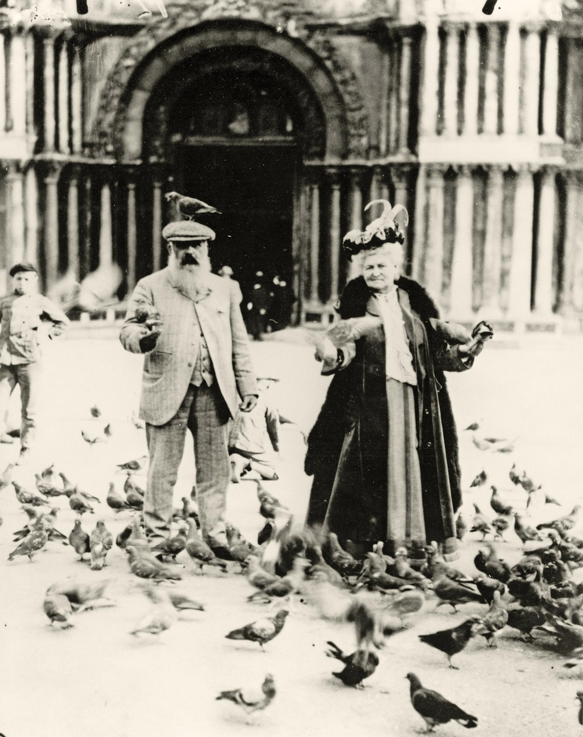 Vintage photo of an older couple feeding pigeons