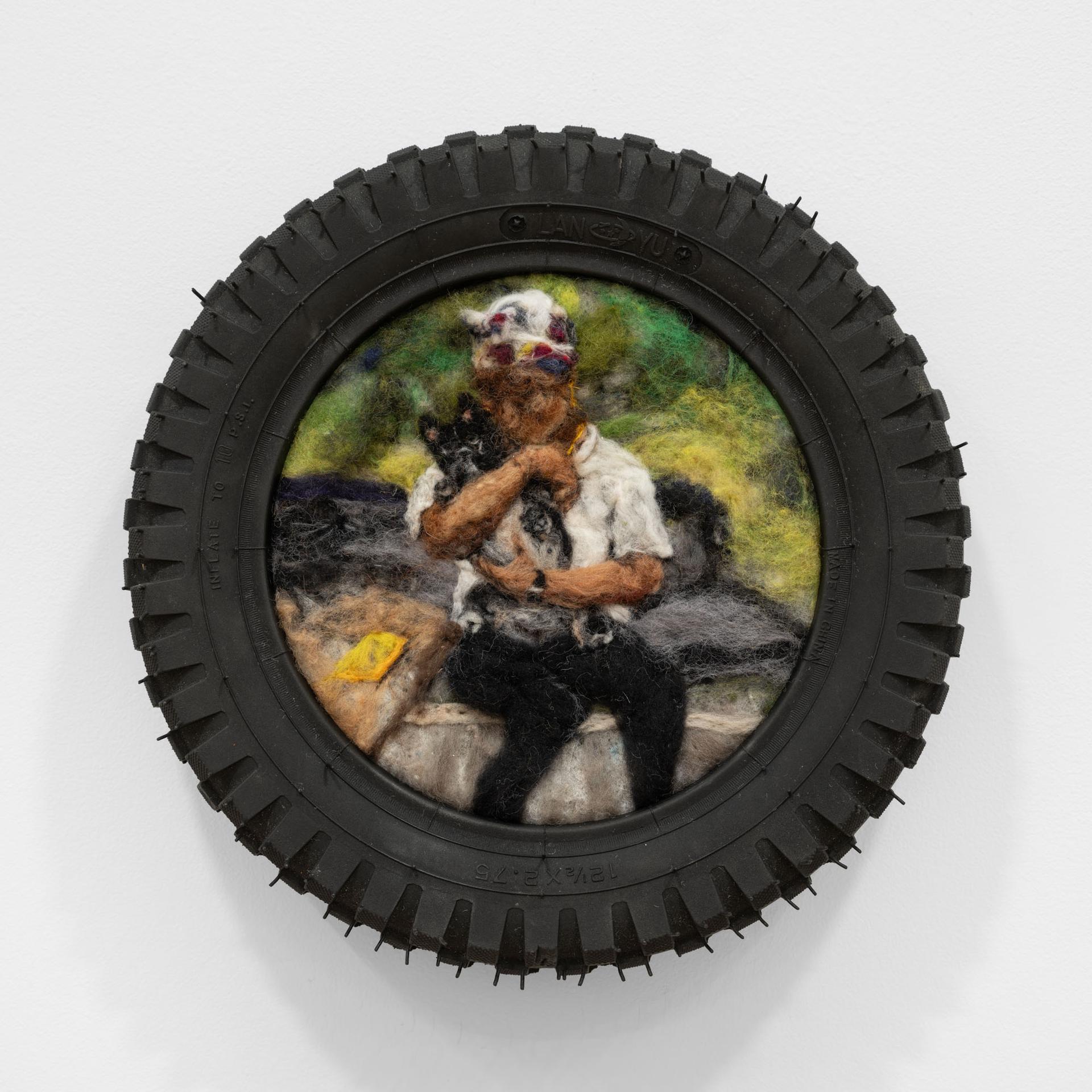 Felted artwork of a person and animal framed in a tire